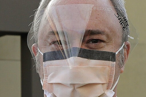 Dr. Stephen Anderson, who works in the Emergency Department at the MultiCare Auburn Medical Center in Auburn, Wash., wears a mask and face shield as he poses for a photo before starting his shift, Tuesday, March 17, 2020, in Auburn, Wash., south of Seattle. Anderson said he writes messages on his shields to identify them as his, and this morning he chose the phrase &quot;Stay Safe.&quot; In the area that has led the country in coronavirus cases and also across the country, hospitals are gearing up for an onslaught of coronavirus patients, but staff on the front lines are stretched thin and don't have enough of the equipment they need to protect themselves from the highly contagious virus. (AP Photo/Ted S. Warren)