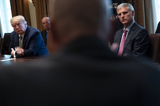 President Donald Trump, left, and Christopher Nassetta, President &amp; CEO of Hilton, listen during a meeting with tourism industry executives about the coronavirus, in the Cabinet Room of the White House, Tuesday, March 17, 2020, in Washington. (AP Photo/Evan Vucci)