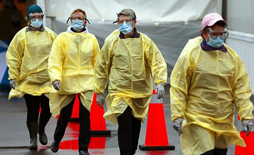 Nurses head out to direct cars into a coronavirus testing center outside the Mercy Virtual Care Center in Chesterfield, Mo., a suburb of St. Louis, on Saturday, March 14, 2020. The drive-thru testing center will open to patients daily from 8 a.m. until 4 p.m. (Robert Cohen/St. Louis Post-Dispatch via AP)