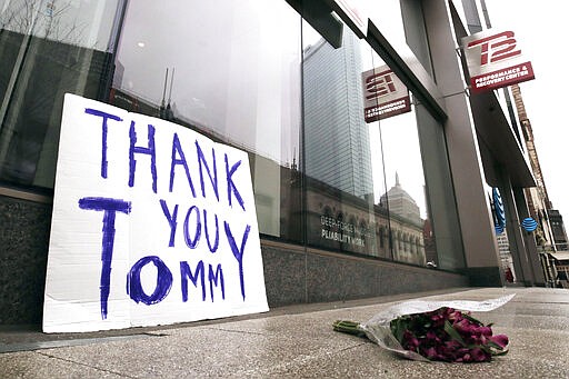 A bouquet of flowers and a sign thanking former New England Patriots quarterback Tom Brady, who announced he was leaving the football team, rest on the sidewalk outside the TB12 training center in Boston, Tuesday, March 17, 2020. (AP Photo/Charles Krupa)