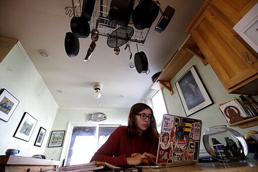 Olivia Marton, an 11th grader at Lincoln Park High School, studies school work with her computer at her home in Chicago, Tuesday, March 17, 2020. Illinois Gov. J.B. Pritzker's executive order closes all kindergarten through 12th grade schools &#151; public and private &#151; &quot;for educational purposes&quot; from March 17 through March 30, due to caronavirus, with students returning to classes March 31. Some individual districts, and some other states, have chosen to keep schools closed longer than that. (AP Photo/Nam Y. Huh)