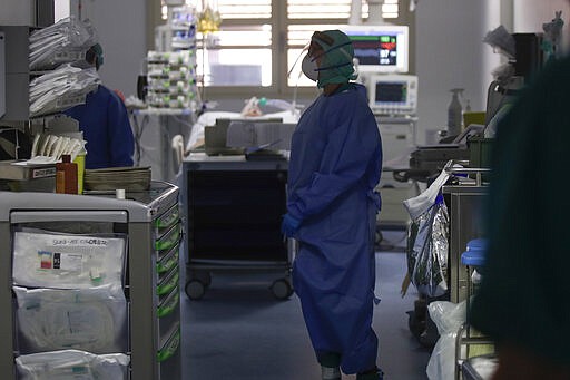 In this March 16, 2020, photo, doctors work in the intensive care unit of the Brescia hospital, Italy. Hospitals in northern Italy are struggling to make room for the onslaught of coronavirus patients. (AP Photo/Luca Bruno)