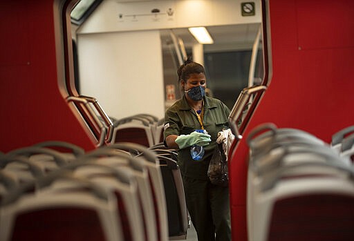 A worker disinfects the cabin of the train that takes tourists to the Christ the Redeemer statue as a precautionary measure to stop the spread of the new coronavirus, in Rio de Janeiro, Brazil, Tuesday, March 17, 2020. For most people, the new coronavirus causes only mild or moderate symptoms, such as fever and cough. For some, especially older adults and people with existing health problems, it can cause more severe illness, including pneumonia. (AP Photo/Silvia Izquierdo)