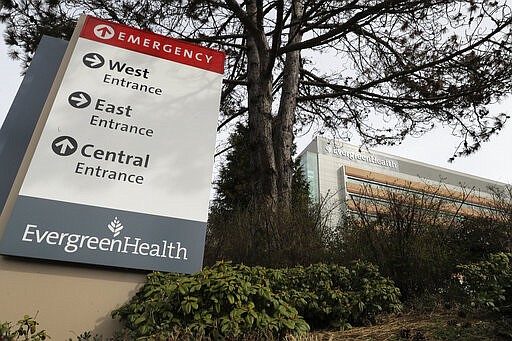 A sign for EvergreenHealth Medical Center is shown, Tuesday, March 17, 2020, in Kirkland, Wash., near Seattle. In the area that has led the country in coronavirus cases and also across the country, hospitals are gearing up for an onslaught of coronavirus patients, but staff on the front lines are stretched thin and don't have the equipment they need to protect themselves from the highly contagious virus. (AP Photo/Ted S. Warren)