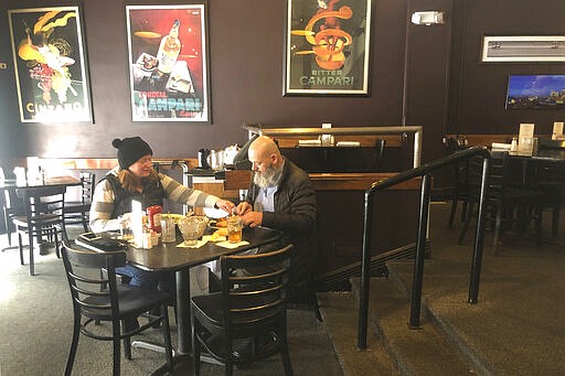 Danny Flanigan and Jennie Mulhall have lunch at their favorite restaurant, the Bristol, in Louisville, Ky., on Monday, March 16, 2020, before the state's lock-down took effect later in the afternoon. &#147;We want to support you one more time while we still can,&#148; Flanigan told the hostess at the nearly empty restaurant. Kentucky was among the states Monday to close down bars, restaurants and other places where people gather. (AP Photo/Claire Galofaro)