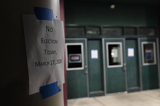 A sign alerts voters that polls are closed for a scheduled primary election on Tuesday, March 17, 2020, at Schiller Recreation Center in Columbus, Ohio. Ohio called off its presidential primary just hours before polls were set to open there and in three other states, an 11th-hour decision the governor said was necessary to prevent further fueling the coronavirus pandemic that has paralyzed the nation. (Joshua A. Bickel/The Columbus Dispatch via AP)