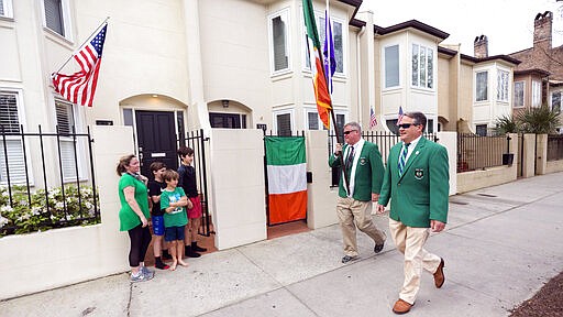 Sinn Fein Society members Bill Bradley, center, and John Lowenthal, right, walk the St. Patrick's Day parade route in downtown Savannah, Ga, Tuesday, March, 17, 2020. Last week Savannah's mayor announced the city's 196-year-old St. Patrick's Day parade was called off due to coronavirus concerns. (AP Photo/Stephen B. Morton)