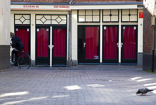 Closed windows of sex workers are seen in the Red Light District of Amsterdam, Netherlands, Monday, March 16, 2020. Health minister Bruno Bruins ordered all Dutch schools, cafes, restaurants coffeeshops, saunas, sex clubs and sport and fitness clubs to be closed from Sunday March 15th onwards as the government sought to prevent the further spread of coronavirus in the Netherlands. For most people, the new coronavirus causes only mild or moderate symptoms, such as fever and cough. For some, especially older adults and people with existing health problems, it can cause more severe illness, including pneumonia. (AP Photo/Peter Dejong)