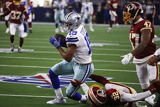 FILE - In this Dec. 15, 2019, file photo, Dallas Cowboys wide receiver Amari Cooper (19) pulls down a reception over Washington Redskins cornerback Jimmy Moreland (32) to help set up a touchdown during the first half of an NFL football game in Arlington, Texas. A person with knowledge of the deal says the Cowboys and top receiver Cooper have agreed on a long-term contract. (AP Photo/Ron Jenkins, File)