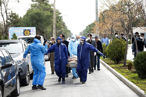 FILE&#151; In this Sunday, March 8, 2020 file photo, men wearing protective gear carry the body of Fatemeh Rahbar, a lawmaker-elect from Tehran constituency, who died on Saturday after being infected with the new coronavirus, at Behesht-e-Zahra cemetery, just outside Tehran, Iran. Nine out of 10 cases of the virus in the Middle East come from the Islamic Republic. For most people, the new coronavirus causes only mild or moderate symptoms. For some it can cause more severe illness. (Mehdi Khanlari/Fars News Agency via AP, File)