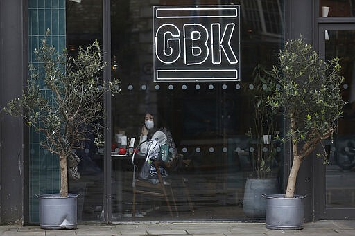 A woman wears a face mask in a restaurant in Dublin city centre, Tuesday March 17, 2020. The St Patrick's Day parades across Ireland were cancelled due to the outbreak of Covid-19 virus. For most people, the new COVID-19 coronavirus causes only mild or moderate symptoms, but for some it can cause more severe illness.(AP Photo/Peter Morrison)