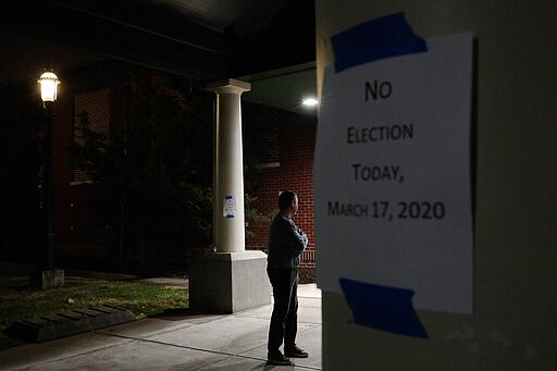 A man, who hoped to vote in the scheduled primary election, stands outside a closed polling station Tuesday, March 17, 2020, at Schiller Recreation Center in Columbus, Ohio.  Ohio called off its presidential primary just hours before polls were set to open there and in three other states, an 11th-hour decision the governor said was necessary to prevent further fueling the coronavirus pandemic that has paralyzed the nation. (Joshua A. Bickel/The Columbus Dispatch via AP)