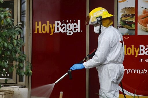 ?An Israeli firefighter sprays disinfectant as a precaution against the coronavirus in Modi'in, Israel, Tuesday, March 17, 2020. The head of Israel's shadowy Shin Bet internal security service said Tuesday that his agency received Cabinet approval overnight to start deploying its counter-terrorism tech measures to help curb the spread of the new coronavirus in Israel. For most people, the new coronavirus causes only mild or moderate symptoms. For some it can cause more severe illness. (AP Photo/Ariel Schalit)