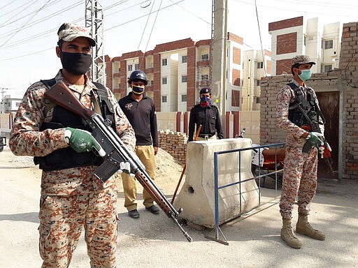 Pakistani security personnel stand guard outside apartments that were converted to a quarantine facility for people suspected of being exposed to the coronavirus after having travelled to Iran, in Sukkar, Pakistan, Tuesday, March 17, 2020. For most people, the new coronavirus causes only mild or moderate symptoms. For some it can cause more severe illness. (AP Photo/Pervez Khan)