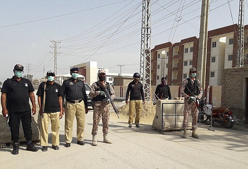 Pakistani security personnel stand guard outside apartments that were converted to a quarantine facility for people suspected of being exposed to the coronavirus after having travelled to Iran, in Sukkar, Pakistan, Tuesday, March 17, 2020. For most people, the new coronavirus causes only mild or moderate symptoms. For some it can cause more severe illness. (AP Photo/Pervez Khan)