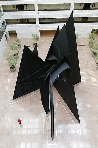 A lone person walks past the &quot;Mountains and Clouds&quot; sculpture by Alexander Calder in the atrium of the Hart office building Tuesday March 17 , 2020, in Washington. (AP Photo/Steve Helber)