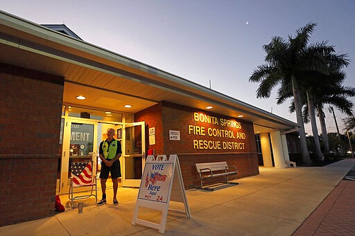 Polling station volunteer Dimitri Uglialoro waits for voters for the Florida presidential primary, Tuesday, March 17, 2020, in Bonita Springs, Fla. Floridians are voting across the state as election officials manage losses of poll workers and changes to polling places because of the coronavirus. There had been concern some polling places might not open on time Tuesday because of worker absences, but no problems have been reported. (AP Photo/Elise Amendola)