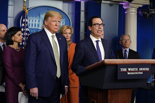 Treasury Secretary Steven Mnuchin speaks during a press briefing with the coronavirus task force, at the White House, Tuesday, March 17, 2020, in Washington, as President Donald Trump looks on. (AP Photo/Evan Vucci)