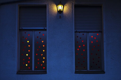 Illuminated hearts cover the windows of the three room brothel 'Lankwitzer 7' in Berlin, Germany, Friday, March 13, 2020. Sex for sale has long been a staple part of the German capital's hedonistic nightlife, but amid concerns over the new coronavirus even the world's supposedly oldest profession is being hit by a sudden slump. For some, especially older adults and people with existing health problems, it can cause more severe illness, including pneumonia.(AP Photo/Markus Schreiber)
