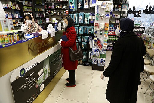 FILE &#151; In this Feb. 29, 2020 file photo, customers wait as a pharmacist prepares medicines, in Tehran, Iran. Nine out of 10 cases of the virus in the Middle East come from the Islamic Republic. Days of denials gave the virus time to spread as the country marked the 41st anniversary of its 1979 Islamic Revolution. Iran also held a parliamentary election in which authorities desperately sought to boost turnout. For most people, the new coronavirus causes only mild or moderate symptoms. For some it can cause more severe illness. (AP Photo/Vahid Salemi, File)