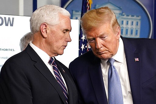 President Donald Trump listens to Vice President Mike Pence during a press briefing with the coronavirus task force, in the Brady press briefing room at the White House, Monday, March 16, 2020, in Washington. (AP Photo/Evan Vucci)