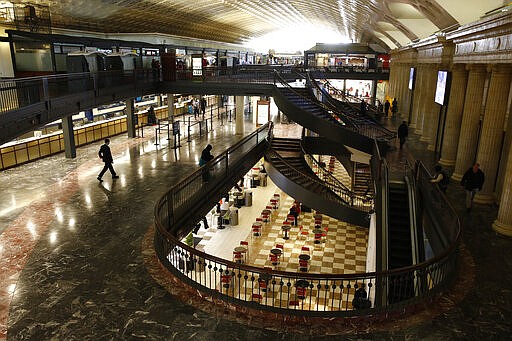 People walk in Union Station in Washington, Monday, March 16, 2020. The U.S. surgeon general says the number of coronavirus cases in the United States has reached the level that Italy recorded two weeks ago. It's a sign that infections are expected to rise in America as the government steps up testing and financial markets continue to fall. (AP Photo/Patrick Semansky)