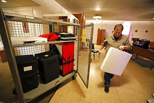 Craig Kuczynsnski packs up a polling place in Our Lady of Lourdes church in Wintersville, Ohio Tuesday, March 17, 2020. Ohio's presidential primary was postponed Tuesday amid coronavirus concerns. (AP Photo/Gene J. Puskar)