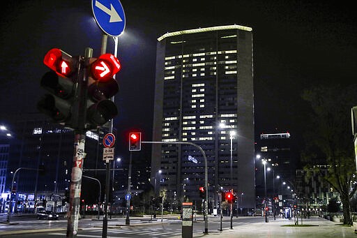 Office lights of the Lombardy region headquarters building in Milan, northern Italy, compose the Italian words 'State a casa' (Stay home), Wednesday, March 18, 2020. Italian authorities say too many people are violating last week's national decree, which allows people to leave homes to go to workplaces, buy food or other necessities or for brief strolls outside to walk dogs or get exercise. For most people, the new coronavirus causes only mild or moderate symptoms, such as fever and cough. For some, especially older adults and people with existing health problems, it can cause more severe illness, including pneumonia.(AP Photo/Luca Bruno)