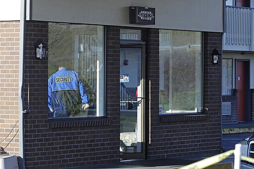 A security guard walks into the front lobby of a former Econo Lodge motel that was purchased by King County to possibly house people under quarantine for the COVID-19 coronavirus, Monday, March 9, 2020, in Kent, Wash., near Seattle. (AP Photo/Ted S. Warren)