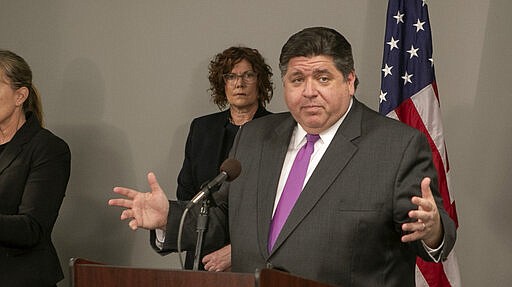 Gov. J.B. Pritzker speaks at a news conference in Belleville, Ill., Wednesday, March 18, 2020, saying he is prepared to order travel and quarantine restrictions in Illinois to limit the spread of coronavirus if scientific guidance recommends. (Derik Holtmann/Belleville News-Democrat via AP)