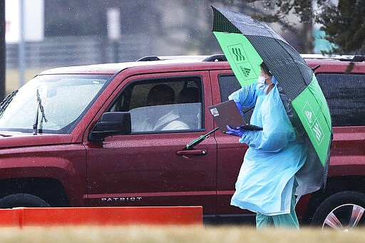 Medical personnel at Advocate Lutheran General Hospital, conduct drive-thru COVID-19 testing in Park Ridge, Ill., Wednesday, March 18, 2020. (AP Photo/Nam Y. Huh)