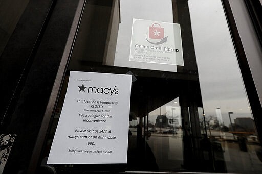 A sign is seen in front of Macy's window at Woodfield Mall in Schaumburg, Ill., Wednesday, March 18, 2020. Macy's has announced it will temporarily close all stores in response to COVID-19 outbreak in the U.S. For most people, the new coronavirus causes only mild or moderate symptoms. For some it can cause more severe illness. (AP Photo/Nam Y. Huh)