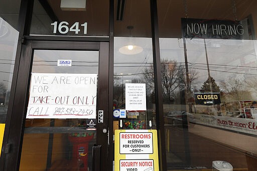 A sign notifies customer of take-out only at a Sushi Station restaurant in Rolling Meadows, Ill., Wednesday, March 18, 2020. All bars and restaurants in the state to have closed their dining rooms through March 30 due to coronavirus concerns. (AP Photo/Nam Y. Huh)