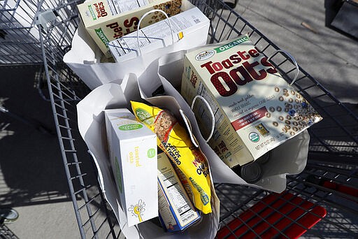 In this Tuesday, March 17, 2020, photo a basket of food sits ready to be loaded on a trailer for delivery at the Des Moines Area Religious Council food pantry in Des Moines, Iowa.  With the new coronavirus leaving many people at least temporarily out of work, food banks and pantries across the U.S. are scrambling to meet an expected surge in demand, even as older volunteers have been told to stay home and calls for social distancing have complicated efforts to package and distribute food. (AP Photo/Charlie Neibergall)