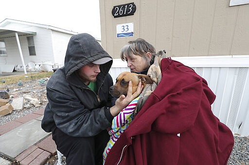 Candy Whisler hugs her dog Athena and grandson Paris Whisler after a  earthquake in Salt Lake City on Wednesday, March 18, 2020. A 5.7-magnitude earthquake has shaken Salt Lake City and many of its suburbs. The quake sent panicked residents running to the streets, knocked out power to tens of thousands of homes and closed the city's airport and its light rail system.  (Jeffrey D. Allred/The Deseret News via AP)