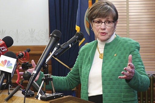 Kansas Gov. Laura Kelly answers questions from reporters after announcing that she'd order all public and private K-12 schools in the state to close for the rest of the semester, Tuesday, March 17, 2020, at the Statehouse in Topeka, Kan. Kelly issued the order in hopes of checking the spread of the coronavirus, and her action will move learning online for students. (AP Photo/John Hanna)