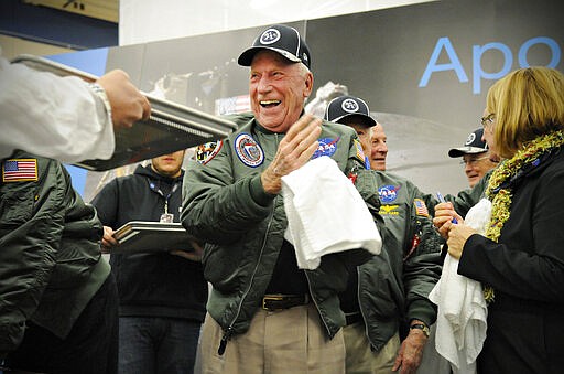 FILE - In this Wednesday, Nov. 12, 2014 file photo, Apollo 15 astronaut Al Worden wipes his hands after creating a cast of his hand prints that will be part of a permanent display at Apollo High School in St. Cloud, Minn. Worden, who circled the moon alone in 1971 while his two crewmates tried out the first lunar rover, has died at age 88, his family said Wednesday, March 18, 2020. (Jason Wachter/St. Cloud Times via AP)