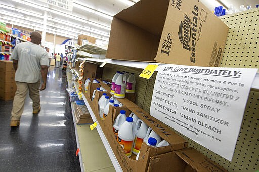 In light of the new coronavirus, Mac's Fresh Market in Ridgeland, Miss., tapes a sign limiting quantities of certain items patrons can buy Tuesday, March 17, 2020. (Barbara Gauntt/The Clarion-Ledger via AP)