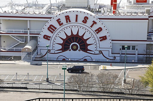 A lone vehicle passes through the empty Ameristar Casino parking lot in Vicksburg, Miss., Tuesday, March 17, 2020. All of Mississippi's state-regulated casinos were ordered closed by midnight Monday to limit the spread of the new coronavirus. (AP Photo/Rogelio V. Solis)