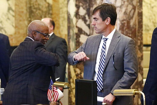 State Sens. Hillman Frazier, D-Jackson, left, and Briggs Hopson III, R-Vicksburg, exchange elbow bumps in lieu of handshakes as they exit the chamber at the Capitol in Jackson, Miss., Wednesday, March 18, 2020, after the Senate voted to adjourn until April 1. The lieutenant governor and speaker of the House may delay a return to the Capitol at their own discretion. (AP Photo/Rogelio V. Solis)