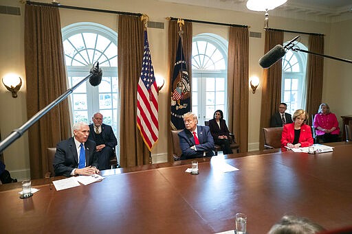 Vice President Mike Pence, left, speaks as President Donald Trump listens, about the coronavirus in the Cabinet Room of the White House during a meeting with representatives of American nurses, Wednesday, March 18, 2020, in Washington. (AP Photo/Alex Brandon)