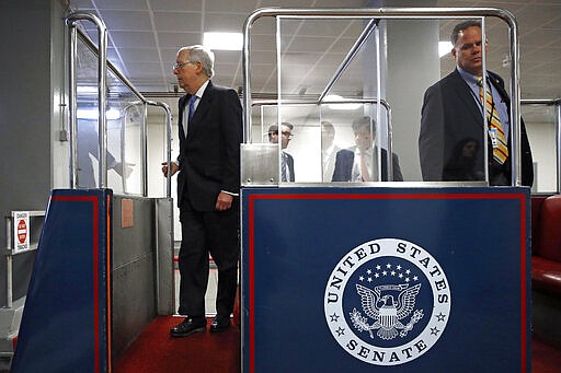 Senate Majority Leader Mitch McConnell of Ky., left, boards a subway car on Capitol Hill in Washington, Wednesday, March 18, 2020, before a vote on a coronavirus response bill. (AP Photo/Patrick Semansky)