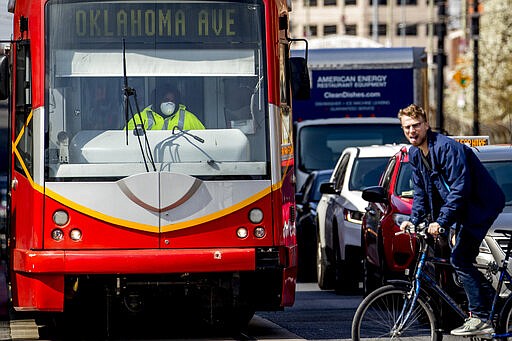 A street car operator wears a face mask as he drives on H Street in Northeast Washington, Wednesday, March 18, 2020. (AP Photo/Andrew Harnik)