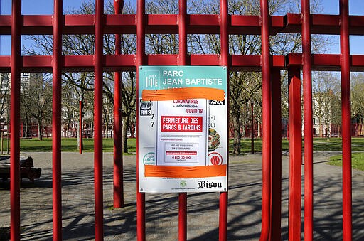 The closed entrance of a park due to coronavirus in Lille, northern France, Wednesday, March 18, 2020. For most people, the new coronavirus causes only mild or moderate symptoms. For some it can cause more severe illness. (AP Photo/Michel Spingler)