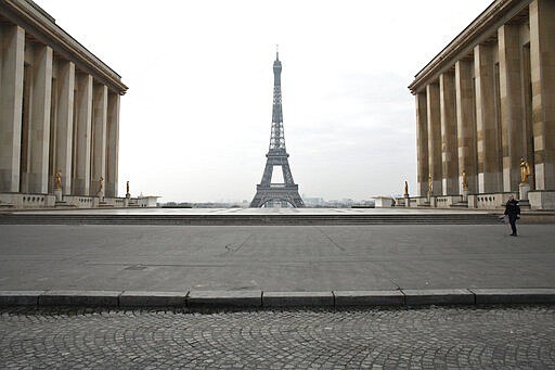 A police officer walks in the empty Trocadero square, in Paris, Wednesday, March 18, 2020. French President Emmanuel Macron said that for 15 days starting at noon on Tuesday, people will be allowed to leave the place they live only for necessary activities such as shopping for food, going to work or taking a walk. For most people, the new coronavirus causes only mild or moderate symptoms. For some it can cause more severe illness, especially in older adults and people with existing health problems. (AP Photo/Thibault Camus)