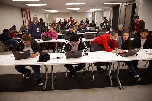 Unionized hospitality workers apply for unemployment benefits at the Hospitality Training Academy Friday, March 13, 2020, in Los Angeles. Fearing a widespread health crisis, Californians moved broadly Friday to get in front of the spread of the coronavirus, shuttering schools that educate hundreds of thousands of students, urging the faithful to watch religious services online and postponing or scratching just about any event that could attract a big crowd.(AP Photo/Marcio Jose Sanchez)