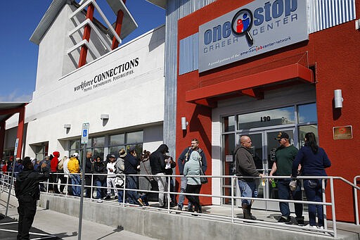 People wait in line for help with unemployment benefits at the One-Stop Career Center, Tuesday, March 17, 2020, in Las Vegas. Nevada Department of Employment, Training and Rehabilitation and its partner organizations, like the One-Stop Career Center, have seen an increase in traffic due to the coronavirus. (AP Photo/John Locher)