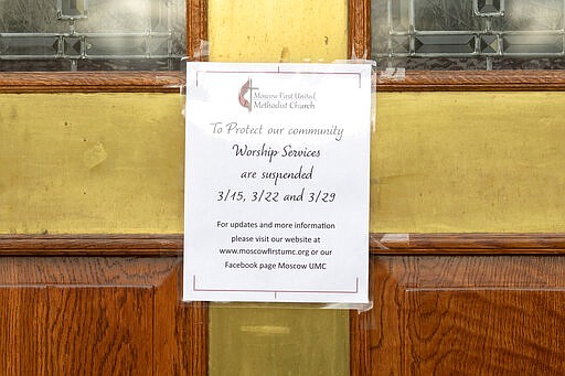 A sign on the door to the First United Methodist Church in Moscow, Idaho, notifies members on Wednesday, March 18, 2020, that church services will be held online through the end of March. The temporary change was made to help slow the spread of the COVID-19 coronavirus. (Geoff Crimmins/Moscow-Pullman Daily News via AP)