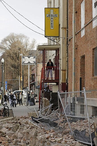 A man looks at the rubble after an earthquake Wednesday, March 18, 2020, in Salt Lake City.  A 5.7-magnitude earthquake has shaken the city and many of its suburbs. The quake sent panicked residents running to the streets, knocked out power to tens of thousands of homes and closed the city's airport and its light rail system.  (AP Photo/Rick Bowmer)