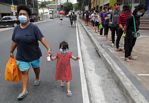 Residents line outside a supermarket in Manila, Philippines, while the government implements a localized quarantine as a precautionary measure against the spread of the new coronavirus, March 17, 2020. (AP Photo/Aaron Favila)